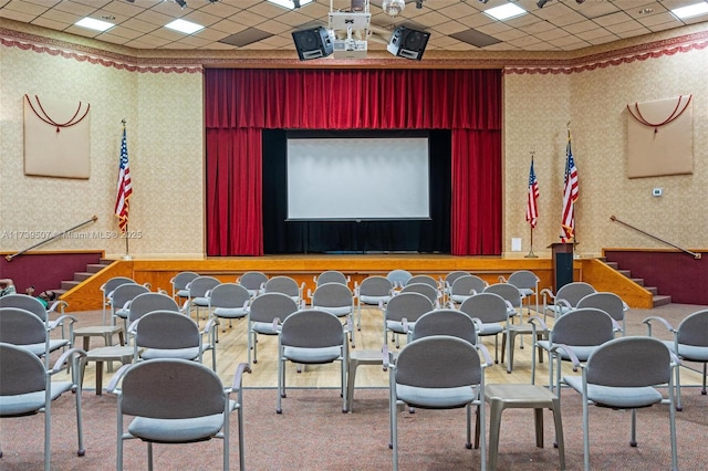 carpeted cinema featuring a drop ceiling