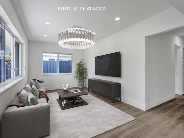 living room featuring an inviting chandelier and wood-type flooring