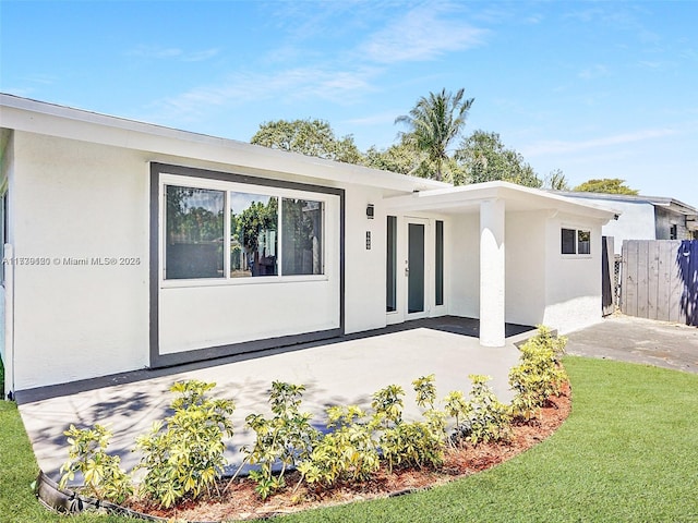 back of property with a yard and a patio area