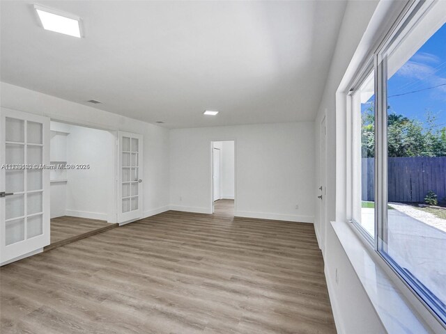 spare room with french doors and light wood-type flooring