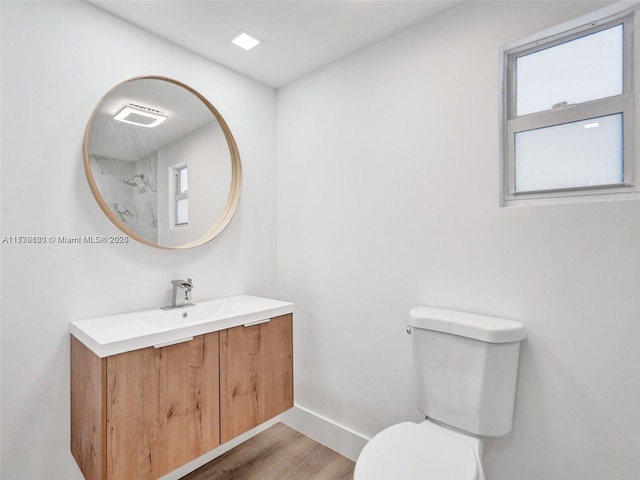 bathroom featuring wood-type flooring, vanity, and toilet