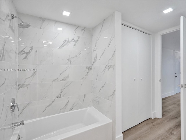 bathroom with tiled shower / bath and hardwood / wood-style floors