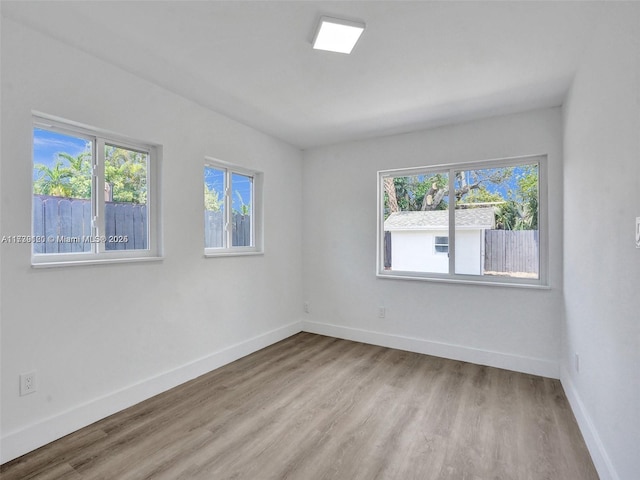 unfurnished room featuring a healthy amount of sunlight and light hardwood / wood-style flooring