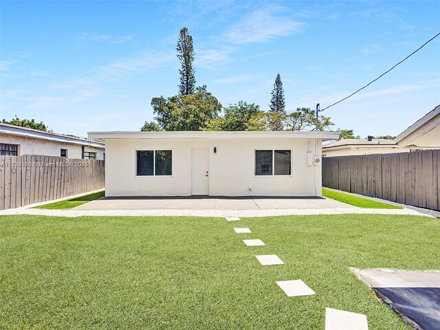 back of house with a lawn and a patio area