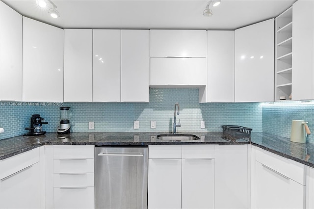 kitchen with white cabinetry, sink, and dark stone countertops