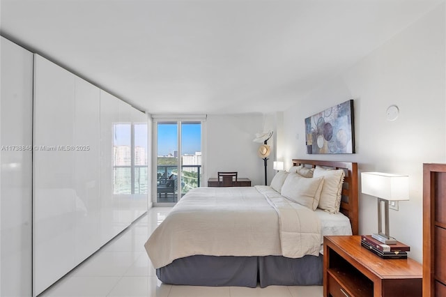 bedroom with light tile patterned floors, expansive windows, and access to exterior