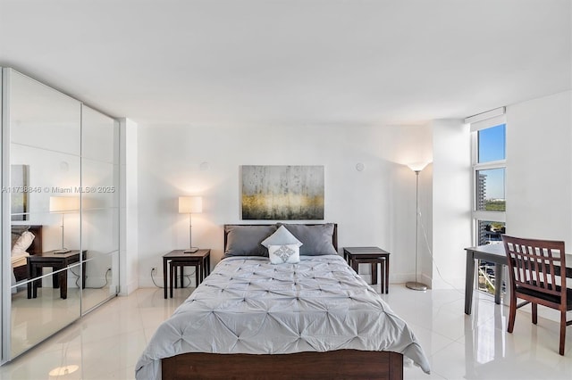 bedroom with light tile patterned flooring and a wall of windows