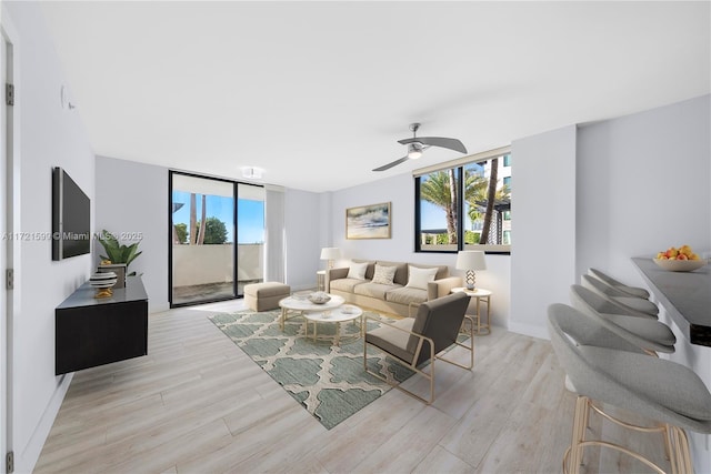 living room with ceiling fan and light hardwood / wood-style flooring