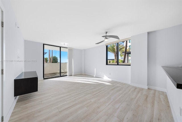 unfurnished living room with ceiling fan and light wood-type flooring