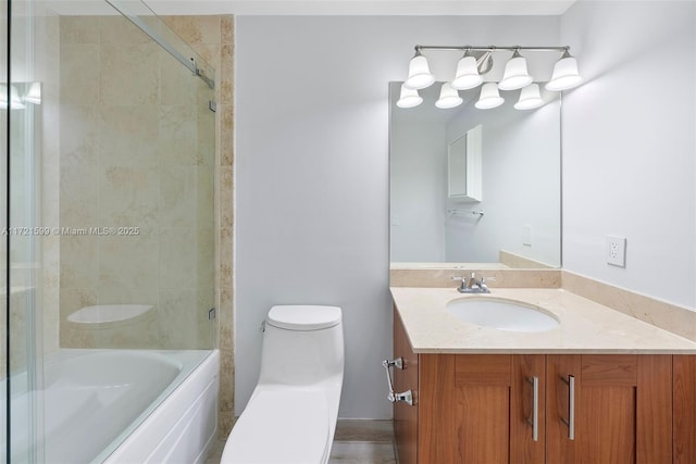 full bathroom featuring vanity, combined bath / shower with glass door, and toilet