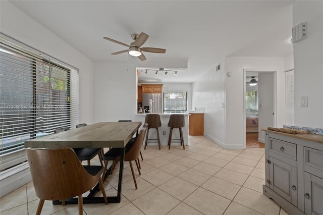 tiled dining space with rail lighting and ceiling fan