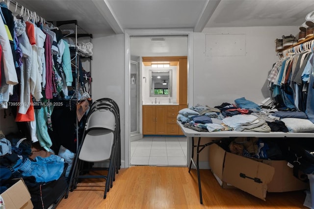 walk in closet with light hardwood / wood-style flooring