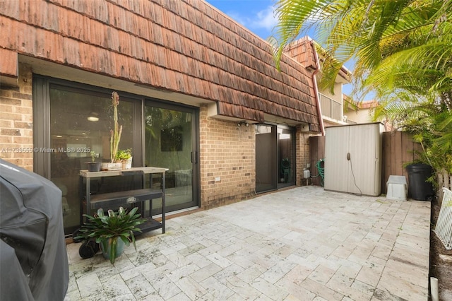 view of patio featuring grilling area and a storage shed