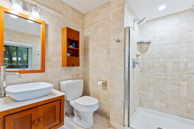 bathroom featuring tile walls, vanity, walk in shower, toilet, and tile patterned floors