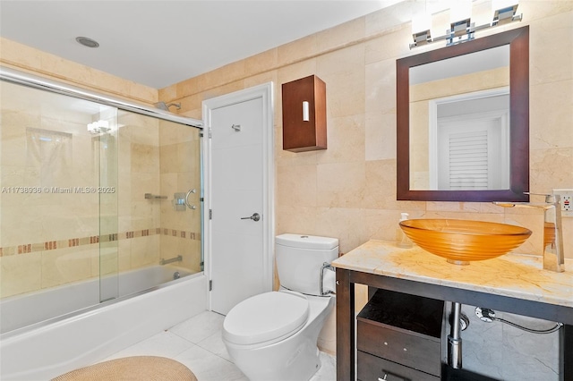 full bathroom with tile patterned flooring, enclosed tub / shower combo, tile walls, and toilet