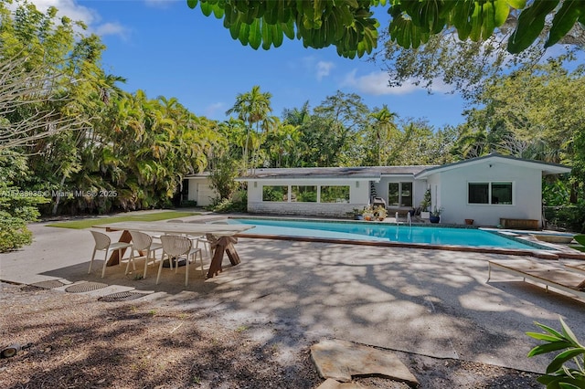 view of pool featuring a diving board and a patio