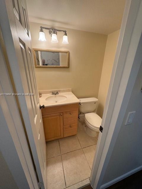 bathroom featuring vanity, tile patterned floors, and toilet