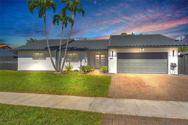 view of front facade with a garage and a lawn