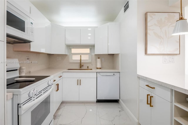 kitchen featuring pendant lighting, sink, white cabinets, decorative backsplash, and white appliances