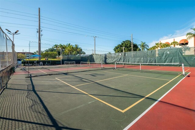 view of tennis court featuring basketball hoop