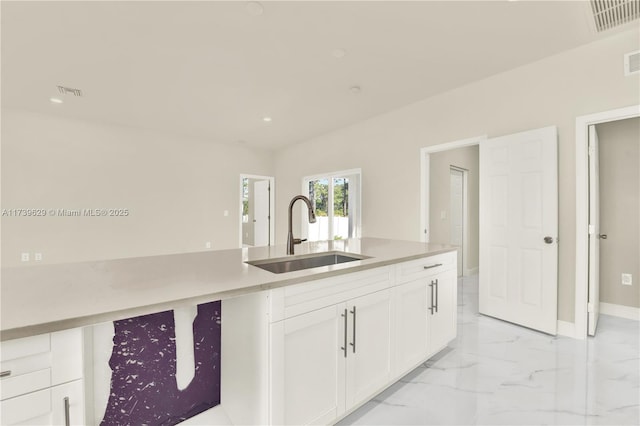 kitchen featuring white cabinetry and sink