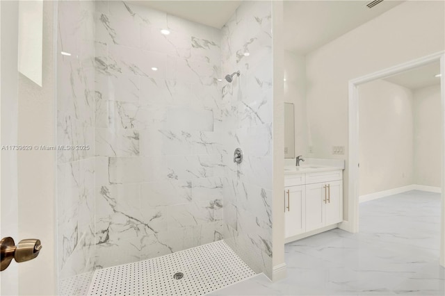 bathroom featuring a tile shower and vanity