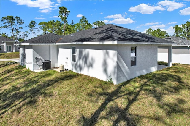 view of side of home featuring central AC and a lawn