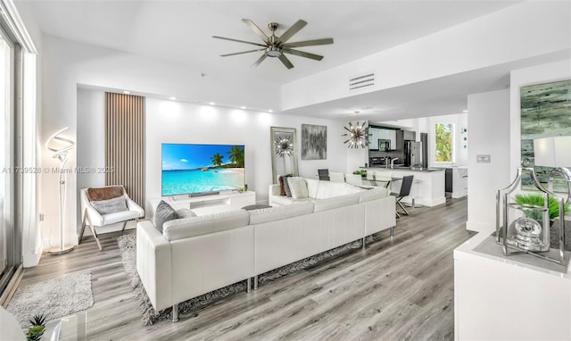 living room featuring ceiling fan and light wood-type flooring