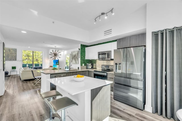 2138 Van Buren St Unit 606, Hollywood, FL 33020 - kitchen with light wood finished floors, visible vents, a peninsula, appliances with stainless steel finishes, and open floor plan