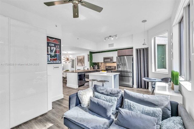 2138 Van Buren St Unit 606, Hollywood, FL 33020 - living room with track lighting, ceiling fan, light wood-style floors, and visible vents