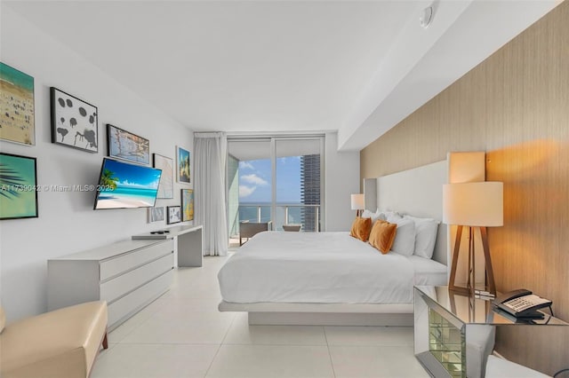 bedroom with light tile patterned flooring, floor to ceiling windows, and access to exterior