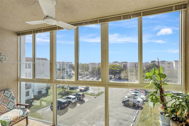 unfurnished sunroom with plenty of natural light and ceiling fan