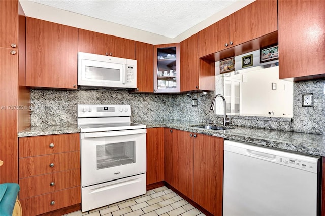 kitchen with tasteful backsplash, white appliances, light stone countertops, and sink