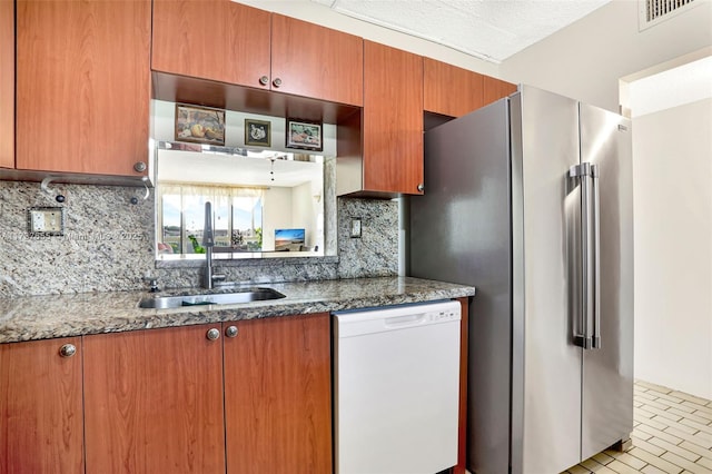 kitchen featuring tasteful backsplash, high quality fridge, dishwasher, and sink