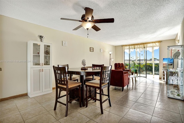 dining space with ceiling fan and a textured ceiling