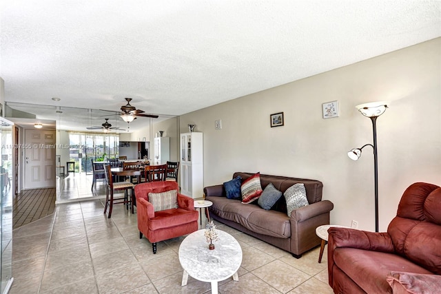 tiled living room with ceiling fan and a textured ceiling