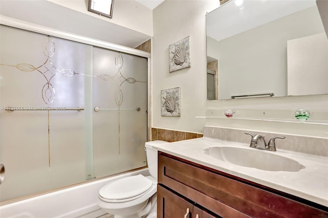 full bathroom featuring vanity, toilet, and combined bath / shower with glass door