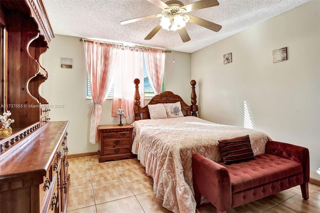 bedroom with ceiling fan, light tile patterned flooring, and a textured ceiling