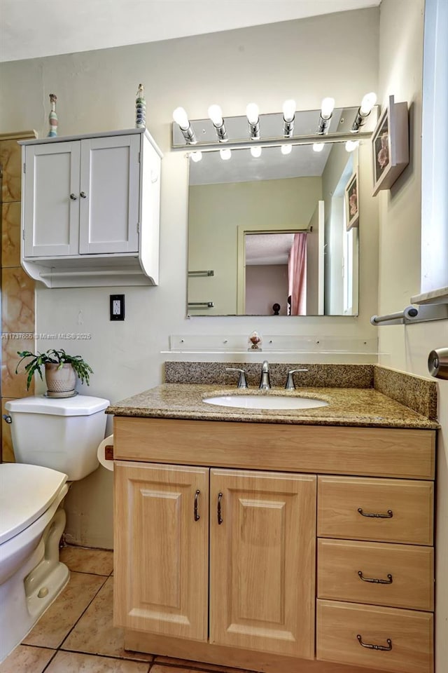 bathroom featuring vanity, toilet, and tile patterned flooring