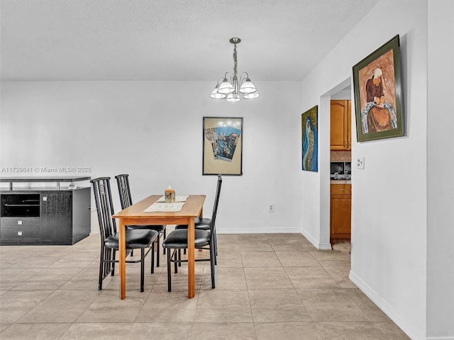 dining space featuring an inviting chandelier, baseboards, and light tile patterned flooring