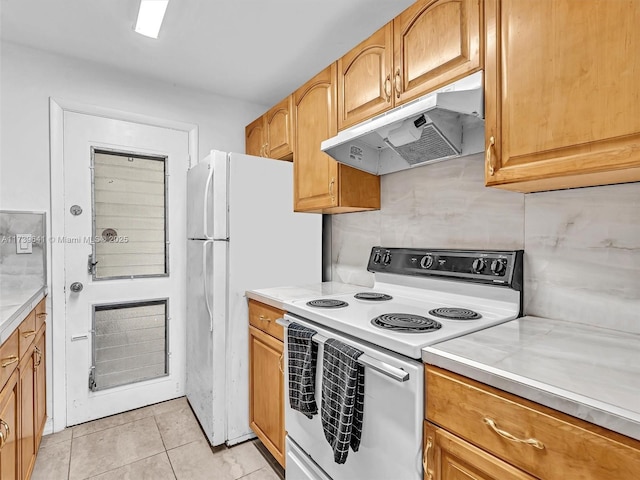 16900 NE 14th Ave Unit 115, Miami, FL 33162 - kitchen with white appliances, under cabinet range hood, light countertops, and light tile patterned flooring