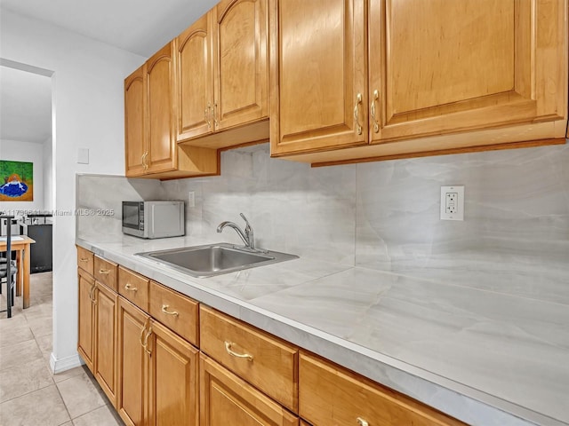 16900 NE 14th Ave Unit 115, Miami, FL 33162 - kitchen with white microwave, light countertops, light tile patterned flooring, and decorative backsplash