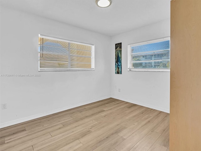 spare room featuring light wood-type flooring and baseboards