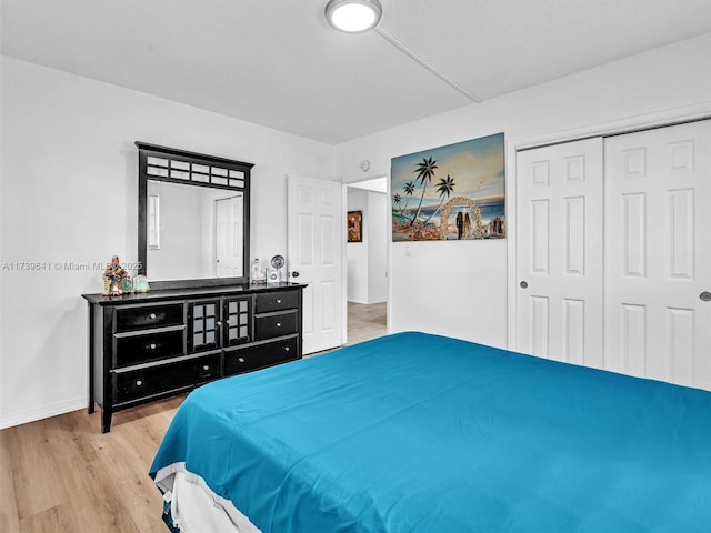 bedroom featuring a closet, wood finished floors, and baseboards