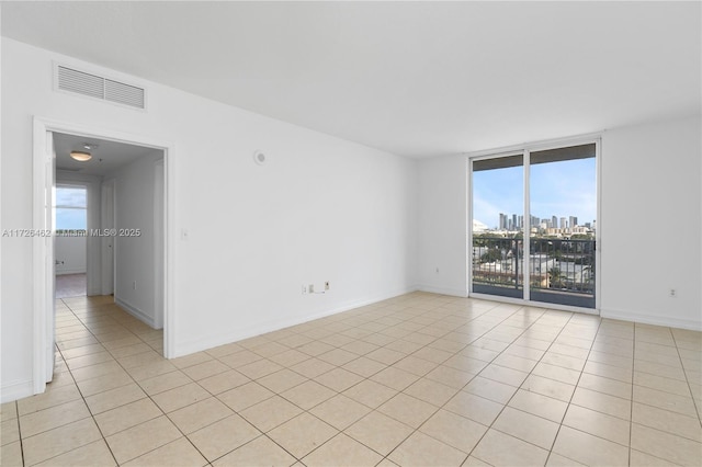 tiled empty room featuring expansive windows and a wealth of natural light