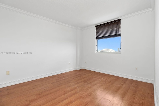 empty room featuring crown molding and light hardwood / wood-style flooring