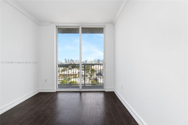 spare room featuring dark wood-type flooring, a wall of windows, and ornamental molding