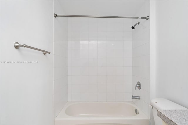 full bathroom with tiled shower / bath, vanity, and toilet