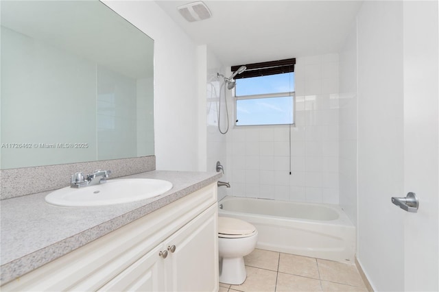 full bathroom featuring tile patterned flooring, tiled shower / bath, vanity, and toilet