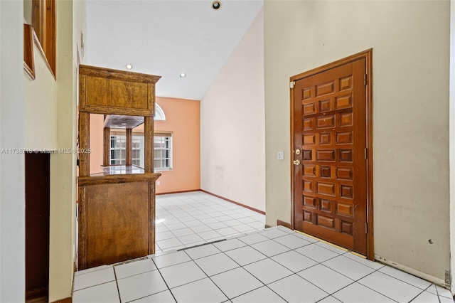 tiled foyer entrance with vaulted ceiling